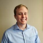 Jack Rain is a Houston Law Clerk in a blue shirt on a beige background